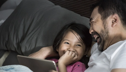 A father and daughter laughing