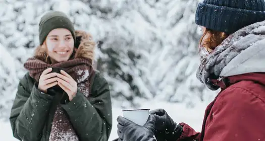 Två kvinnor som fikar utomhus. Foto.