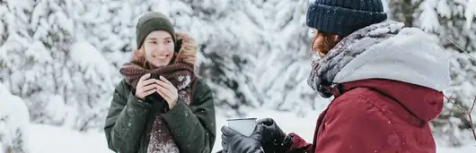 Två kvinnor som fikar utomhus. Foto.