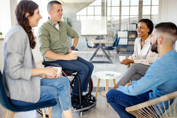 Group of four business people discussing and laughing