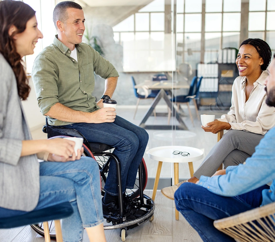 Group of four business people discussing and laughing