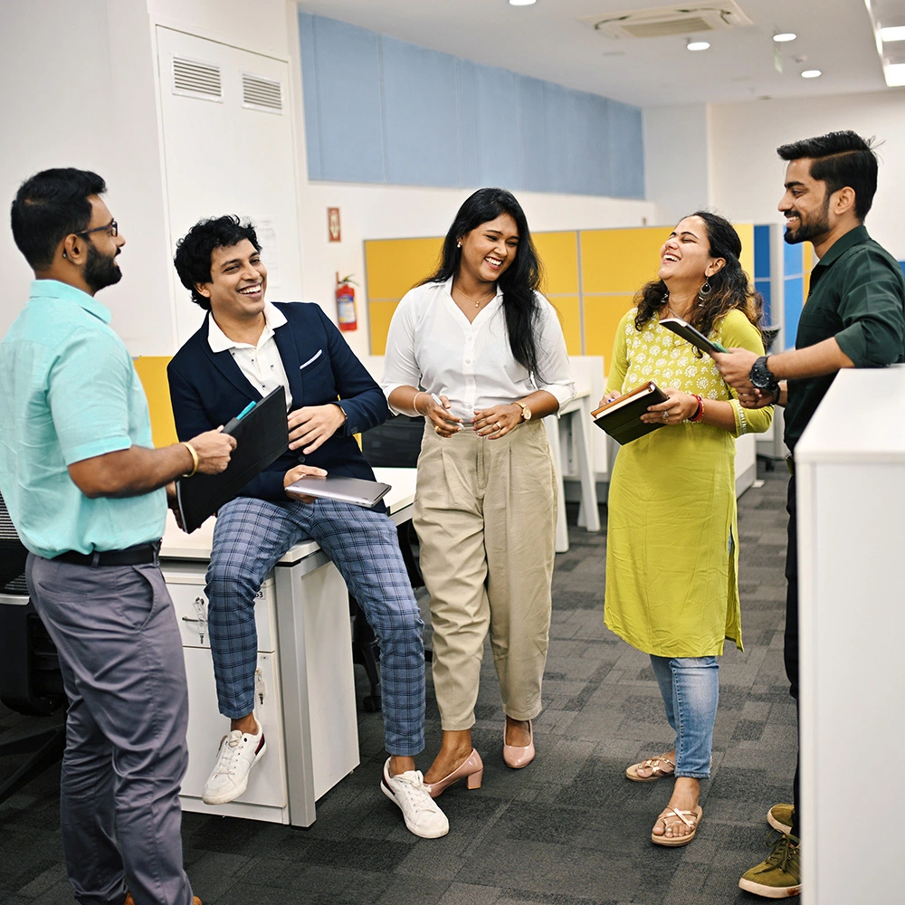 Group of five business people in India discussion and laughing