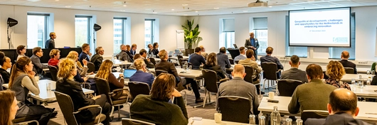 Groep professionals volgt een presentatie in een zaal